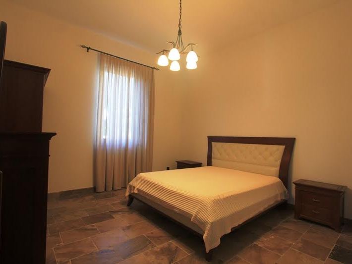 Gemütliches Schlafzimmer mit Doppelbett und Steinboden in einer Villa in Petrovac, Montenegro.
