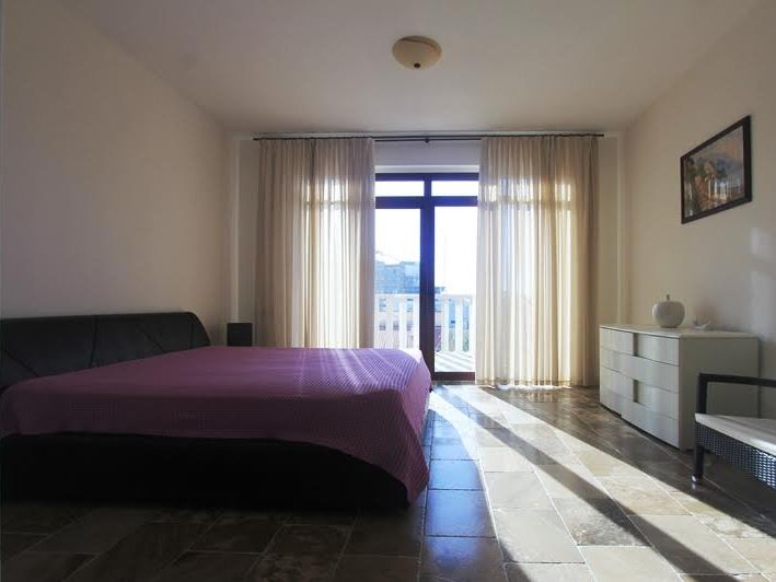 Helles Schlafzimmer mit Doppelbett und Zugang zum Balkon in einer Villa in Petrovac, Montenegro.