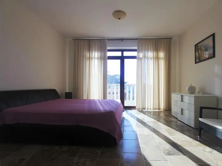 Helles Schlafzimmer mit Doppelbett und Zugang zum Balkon in einer Villa in Petrovac, Montenegro.