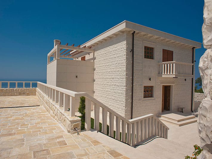 Villa en pierre de deux étages à Reževići, Monténégro, avec une terrasse spacieuse et une vue panoramique sur la mer Adriatique.