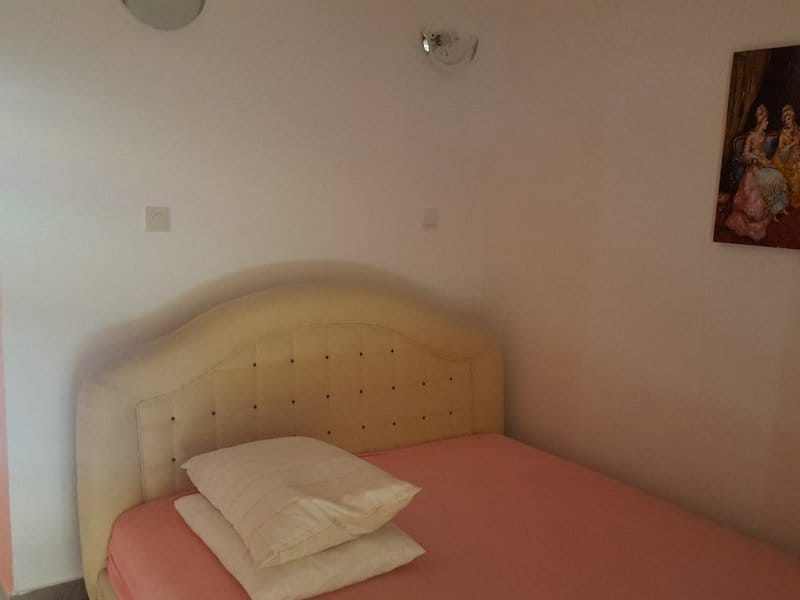 Satılık evde çift kişilik yataklı уютная yatak odası, Krimovitsa, Karadağ: aydınlık iç mekan ve duvar dekoru.