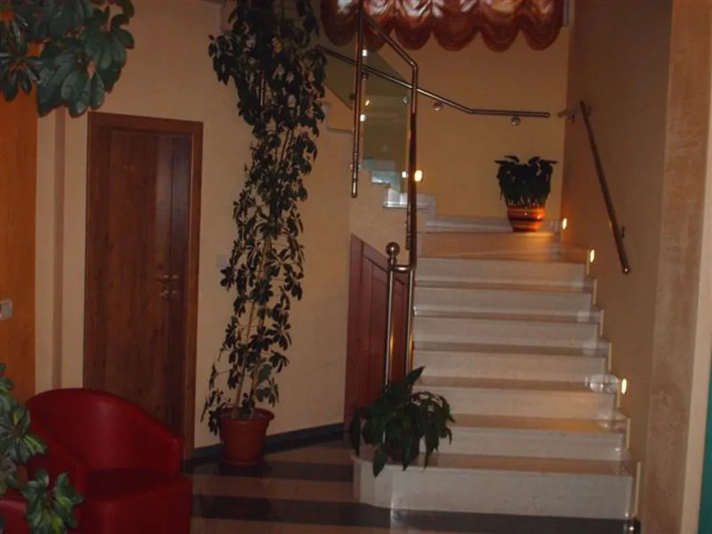 Innenraum der Hotellobby eines Mini-Hotels in Bijela, Montenegro: Marmortreppe mit Beleuchtung, Glasgeländer und Zimmerpflanzen.
