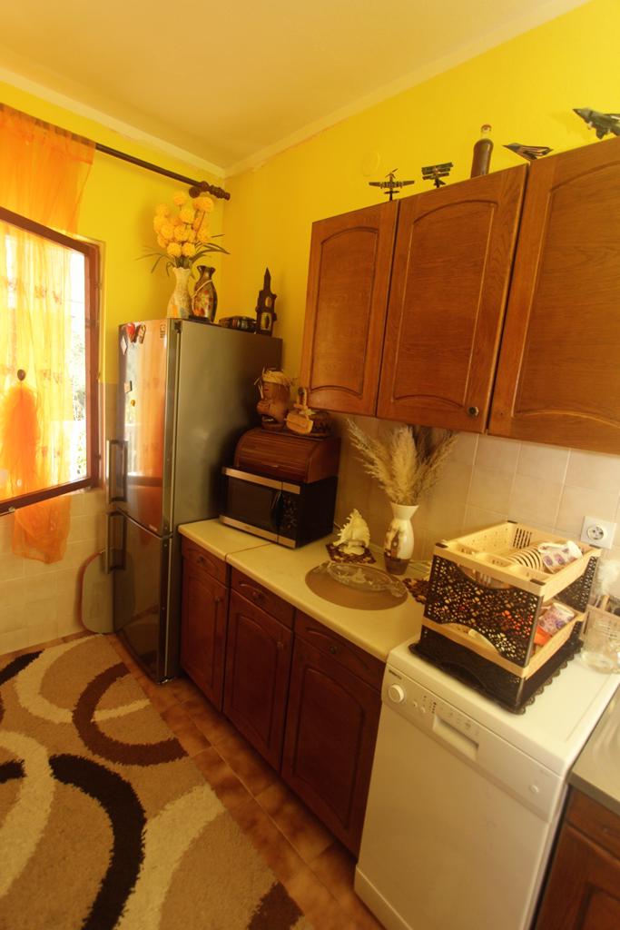 Gemütliche Küche mit Holzschränken und Haushaltsgeräten in einem Haus zum Verkauf, Herceg Novi, Montenegro.
