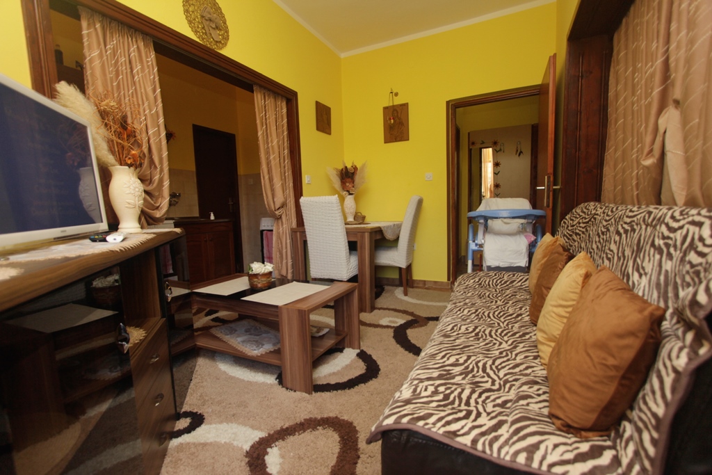 Wohnzimmer in einem Haus in Herceg Novi, Montenegro: Sofa mit Muster, Essbereich, gelbe Wände und gemütliches Interieur.