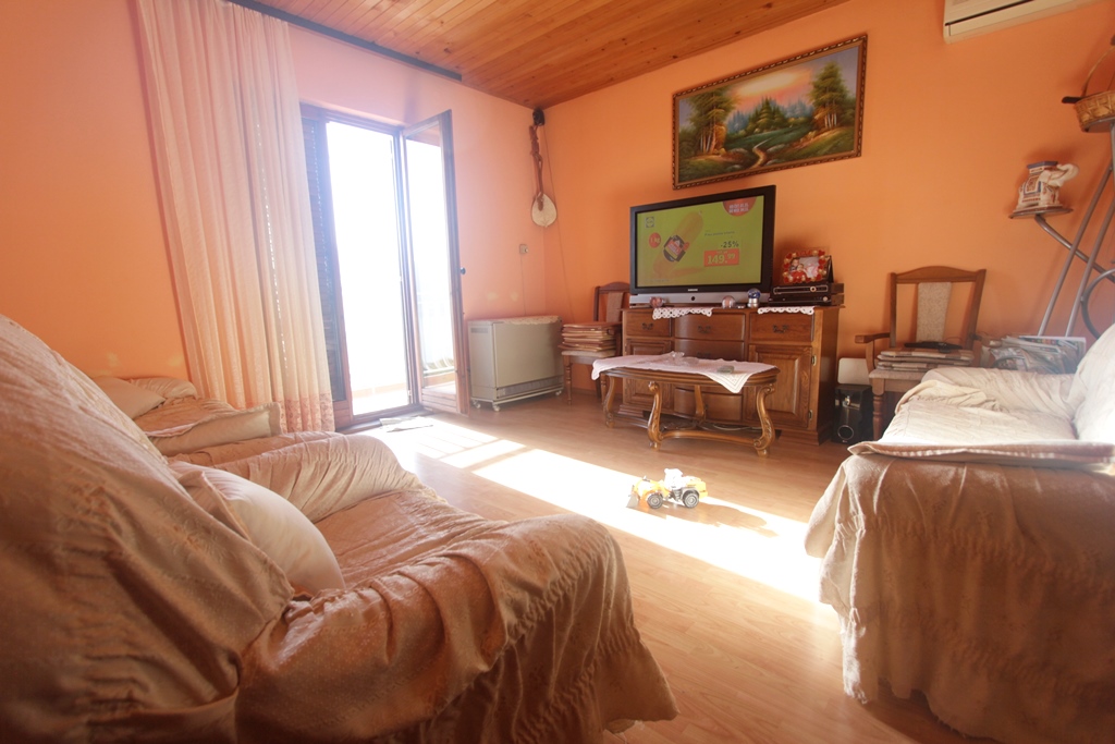 Gemütliches Wohnzimmer mit Holzdecke und Zugang zur Terrasse im Haus, Herceg Novi, Montenegro: Polstermöbel und TV-Bereich.
