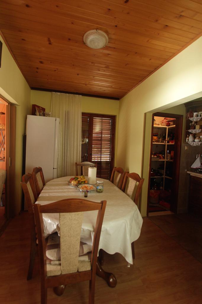 Essbereich im Haus in Herceg Novi, Montenegro: Holzdecke, Tisch mit Stühlen und Blick auf die Speisekammer.