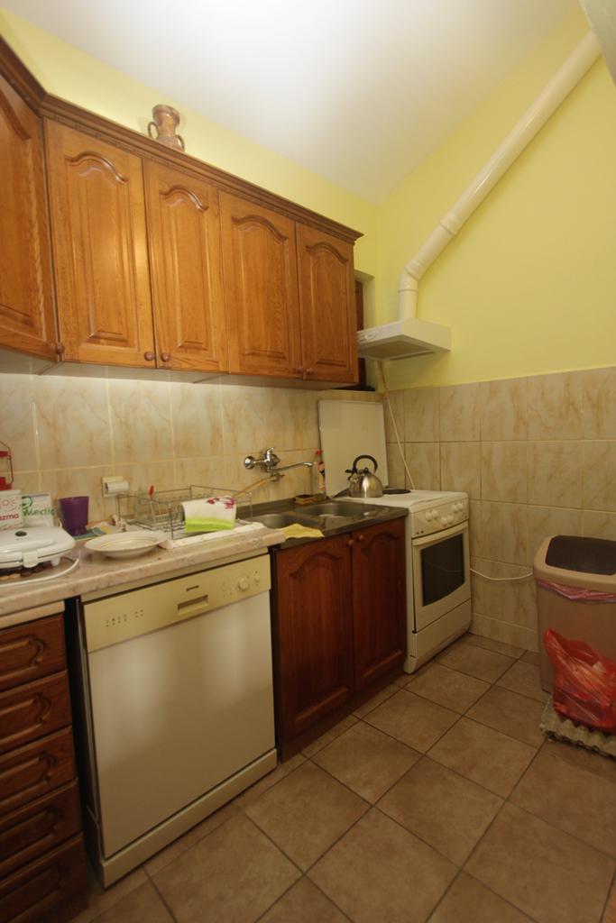 Küche mit Holzfronten, Herd und Geschirrspüler in einem Haus in Herceg Novi, Montenegro.