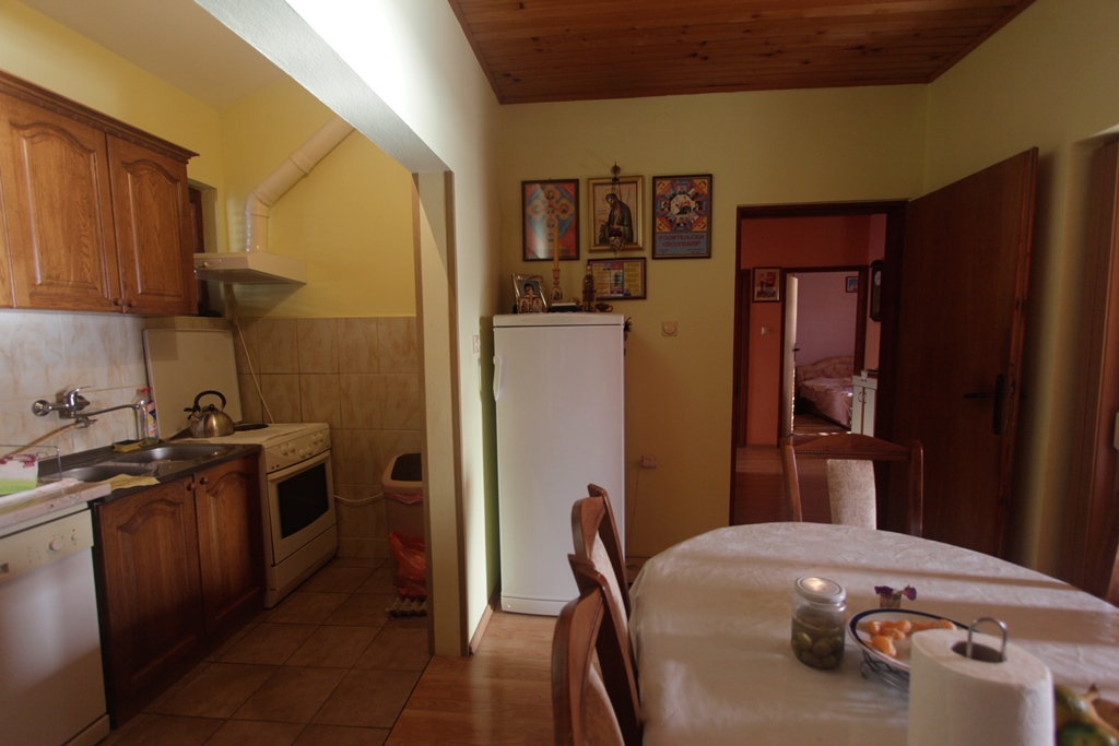 Küche mit Holzmöbeln und Essbereich im Haus, Herceg Novi, Montenegro. Blick auf den Innenraum und den Durchgang zum Schlafzimmer.