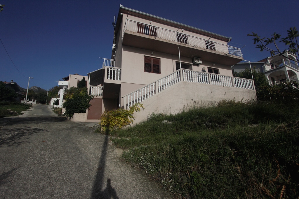Zweistöckiges Haus mit Terrasse und Balustrade in Herceg Novi, Montenegro: Blick auf die Fassade des Gebäudes mit angrenzender Straße.