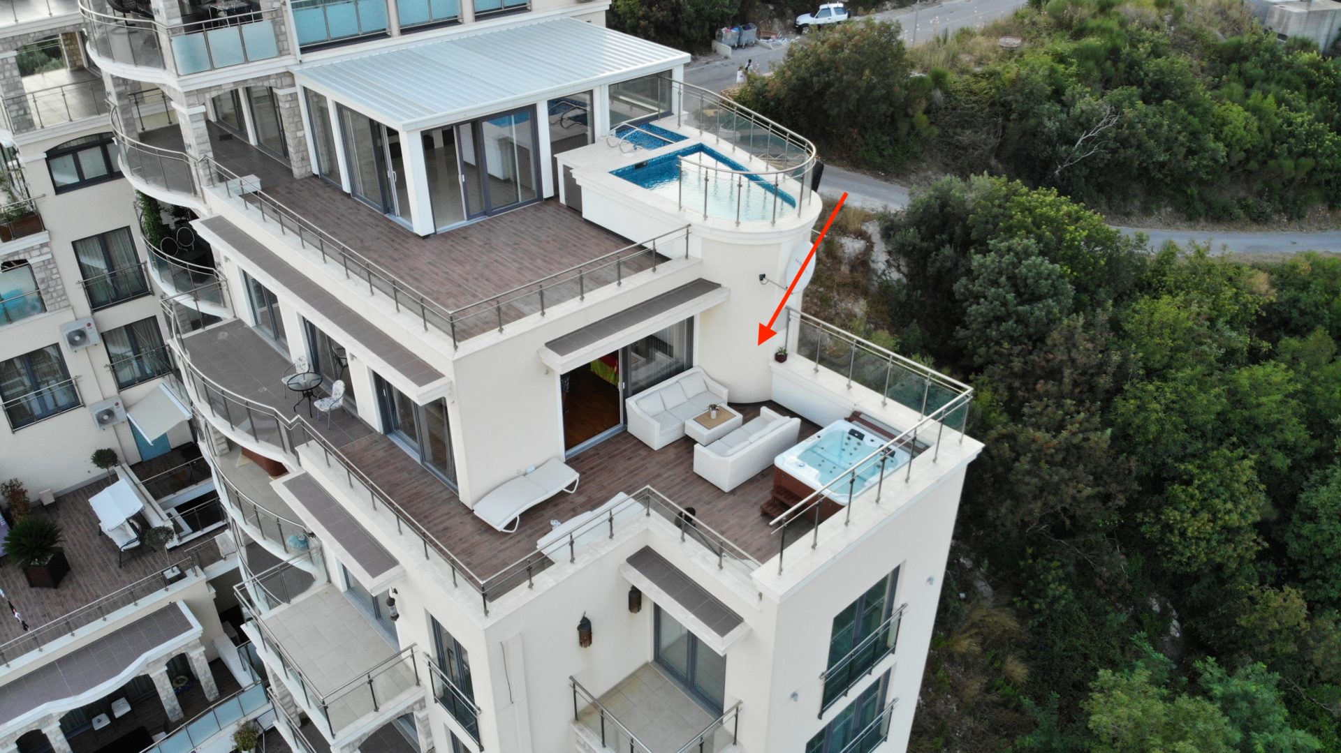 Penthouse in Bečići, Montenegro: Terrasse mit Jacuzzi, Lounge-Möbeln und Meerblick in einer exklusiven Wohnanlage.