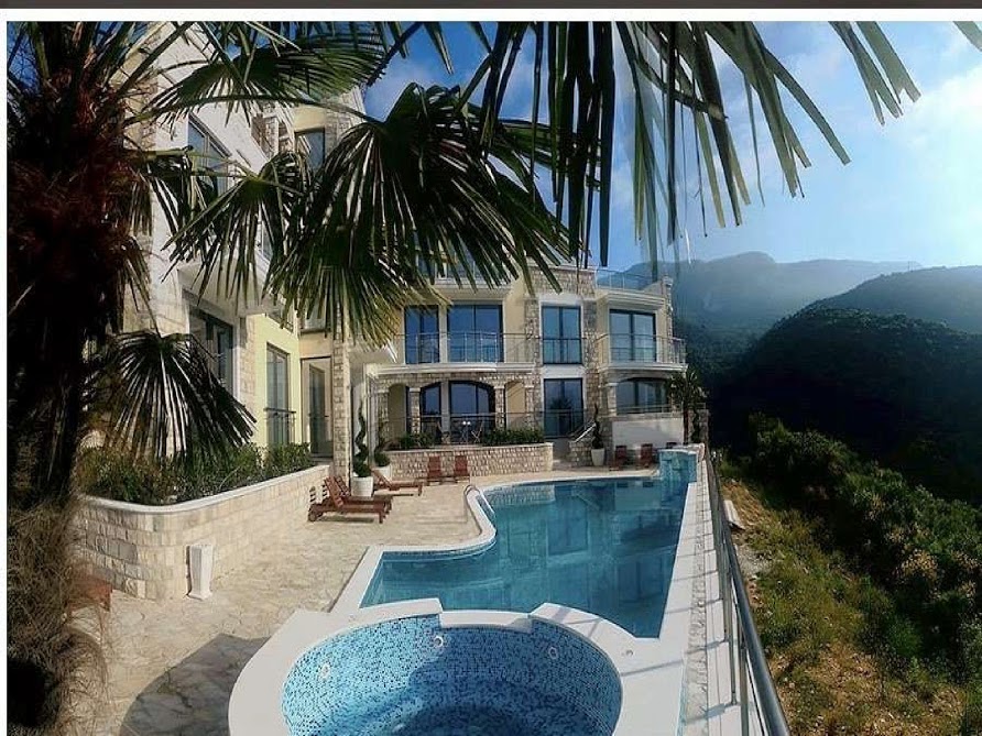 Pool und Jacuzzi auf der Terrasse einer Luxusvilla in Bečići, Montenegro, mit Panoramablick auf die Berge und das Meer.