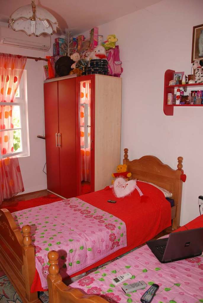 Kinderzimmer mit zwei деревянными Betten und rotem Schrank in einem Haus zum Verkauf in Kamenari, Montenegro.