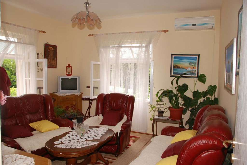Gemütliches Wohnzimmer mit Ledermöbeln in einem Haus zum Verkauf in Kamenari, Montenegro: helles Interieur, Klimaanlage und Dekor.