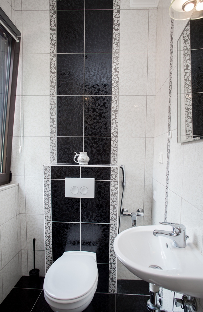 Modernes Badezimmer mit schwarz-weißen Fliesen in einem Haus in Orahovac, Bucht von Kotor, Montenegro.