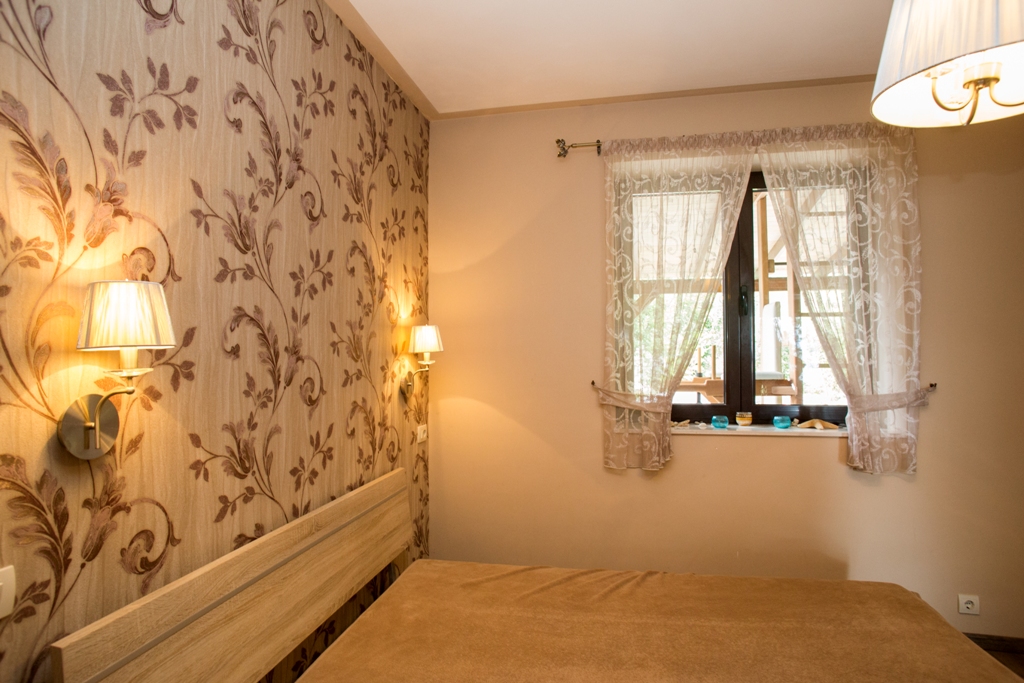 Gemütliches Schlafzimmer mit Doppelbett und Tapete mit Blumenmuster in einem Haus in Orahovac, Bucht von Kotor, Montenegro