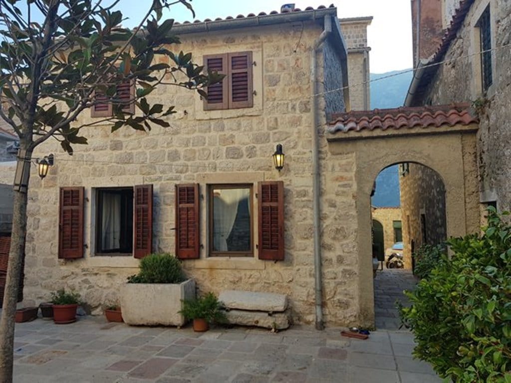 Karadağ, Prčanj şehrinde ahşap panjurlu Akdeniz tarzı taş villanın cephesi.
