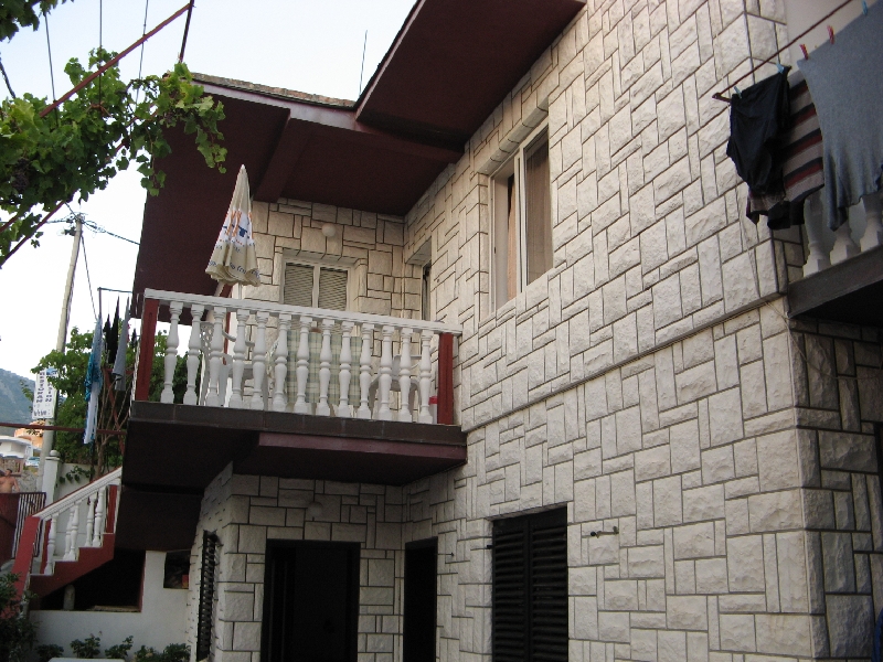 Maison à deux étages à Shushan, Monténégro : façade en pierre claire, balcon avec balustrade et terrasse de style méditerranéen