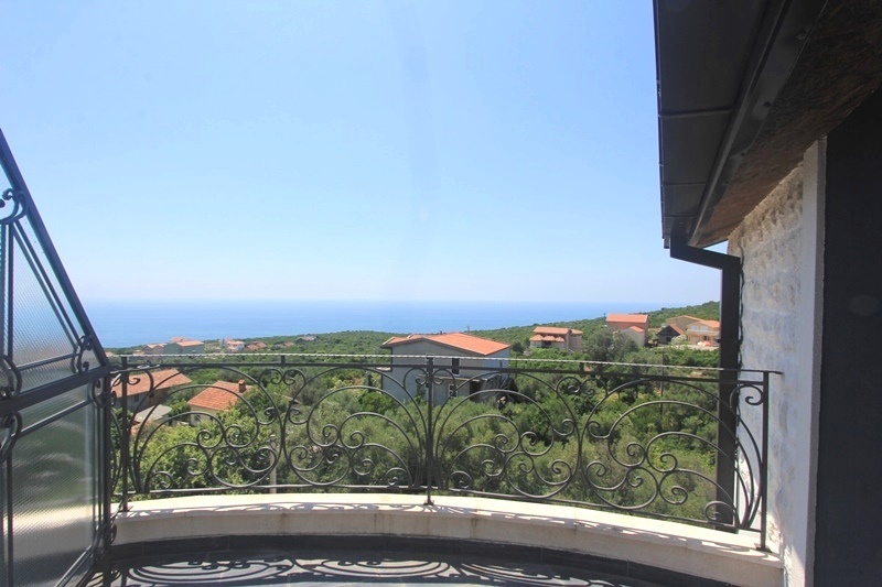 Balkon sa kovanom ogradom i panoramskim pogledom na more i planine u kući, naselje Krimovica, Crna Gora.