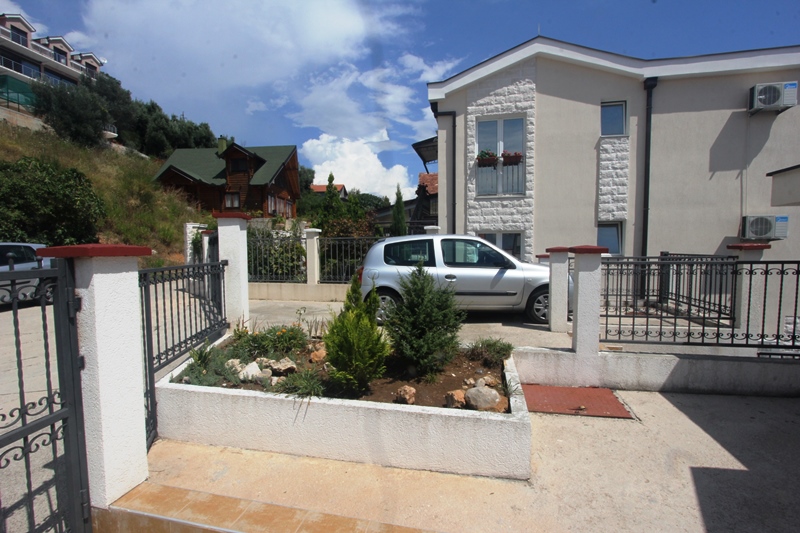 Zweistöckiges Haus mit Parkplatz und Landschaftsgestaltung in Baošići, Montenegro: Blick auf die Fassade und das Grundstück.