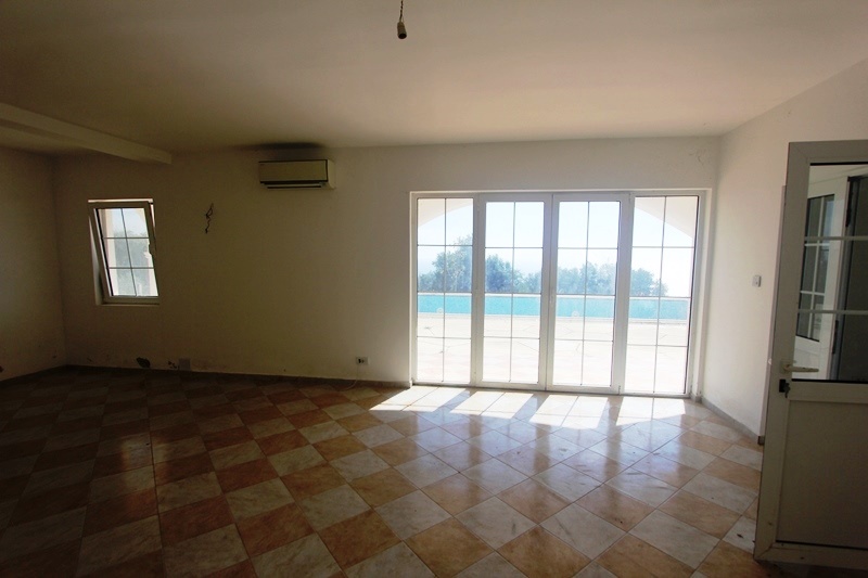 Bright living room with panoramic windows and access to the pool in a villa in Dobra Voda, Montenegro.