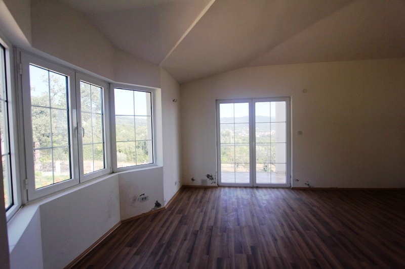 Bright living room with panoramic windows and mountain views in a villa, Dobrye Vody, Montenegro: laminate flooring and white walls.