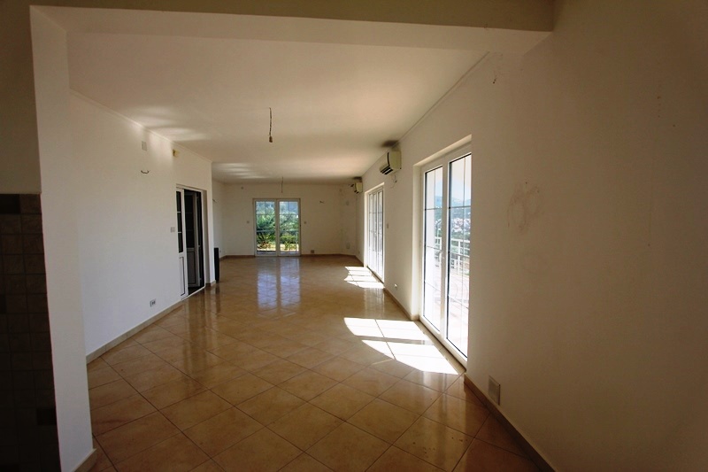 Spacious living room with panoramic windows and tiled floor in a villa in Dobra Voda, Montenegro.