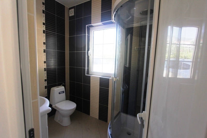 Modern bathroom with a shower cabin in a villa, Dobri Vody, Montenegro: tiled finish and a window in the bathroom.