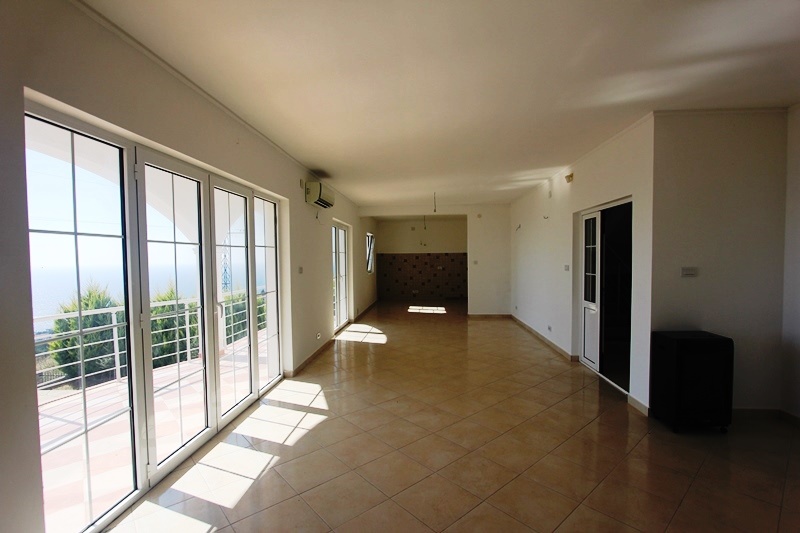 Spacious living room with panoramic windows and sea view in a villa, Dobrota, Montenegro. Tiled floor, light walls.
