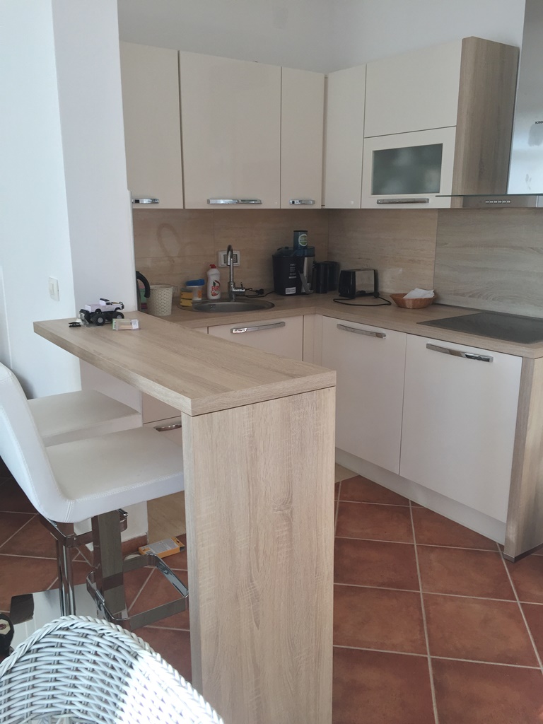 Savremena kuhinja sa barskim pultom i svetlim frontovima u vili u Dobrim Vodama, Crna Gora.