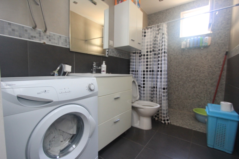 Badezimmer im Haus, Seoce, Montenegro: Waschmaschine, Waschtisch mit Waschbecken, Dusche mit Vorhang und Fliesenverkleidung.