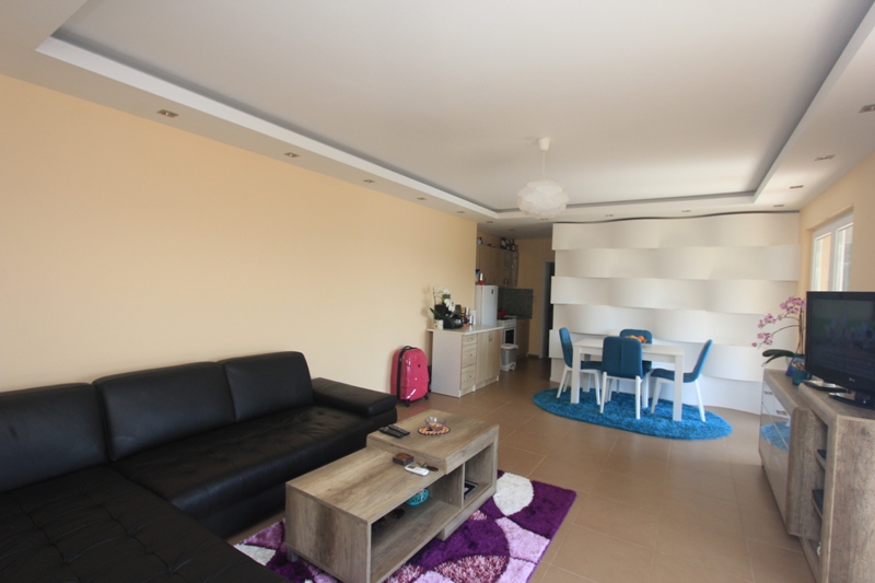 Wohnzimmer mit schwarzem Ledersofa und Essbereich in einem Haus, Seoce, Montenegro: modernes Interieur mit Wanddekoration.