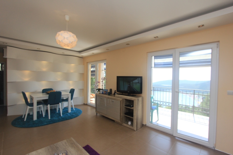 Wohnzimmer mit Essbereich in einem Haus in Seoce, Montenegro: moderne Möbel, Designerbeleuchtung und Meerblick.