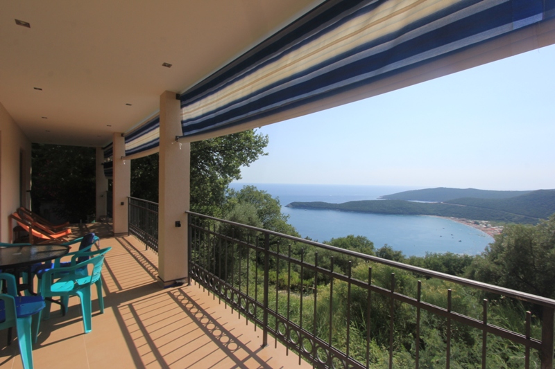 Geräumige Terrasse mit Meerblick in einem Haus in Seoce, Montenegro: Kunststoffmöbel, Überdachung und schmiedeeisernes Geländer.