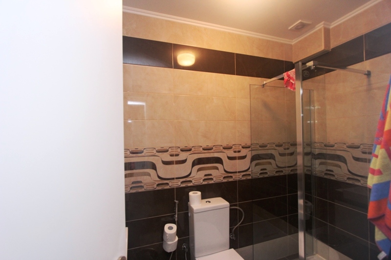 Badezimmer in einem Haus in Utjeha, Montenegro: moderne Duschkabine und Fliesenverkleidung in Beige- und Brauntönen.