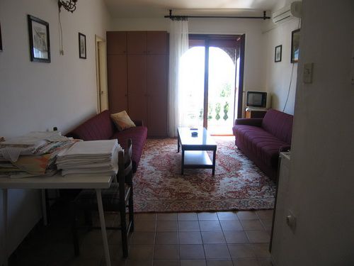 Wohnzimmer in einem Haus in Bečići, Montenegro: zwei Sofas, Couchtisch, Teppich und Zugang zum Balkon mit Aussicht.