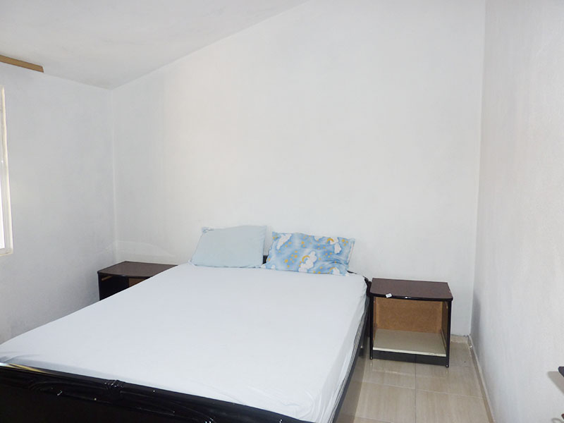 Helles Schlafzimmer mit Doppelbett und Nachttischen in einem Haus zum Verkauf, Dobri Vody, Montenegro.