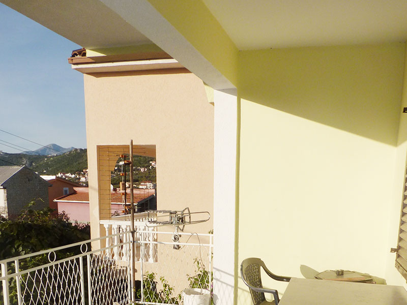 Geräumiger Balkon des Hauses in Dobri Vody, Montenegro, mit Blick auf die Berge und benachbarte Villen, Kunststoffmöbel.
