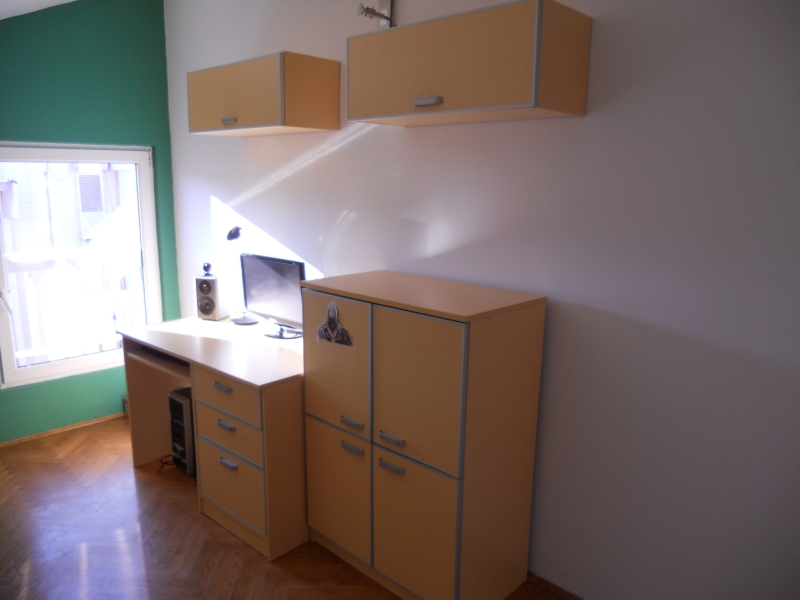 Arbeitsbereich im Schlafzimmer einer Wohnung in Budva, Montenegro: Schreibtisch, Schränke, Computer und Parkettboden.