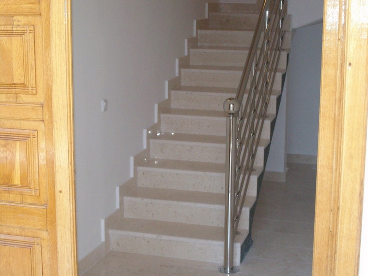 Treppe mit Marmorstufen und einem Metallhandlauf