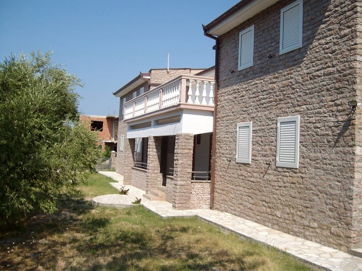 Fassade eines zweistöckigen Stein Hauses mit Balkon und Weg
