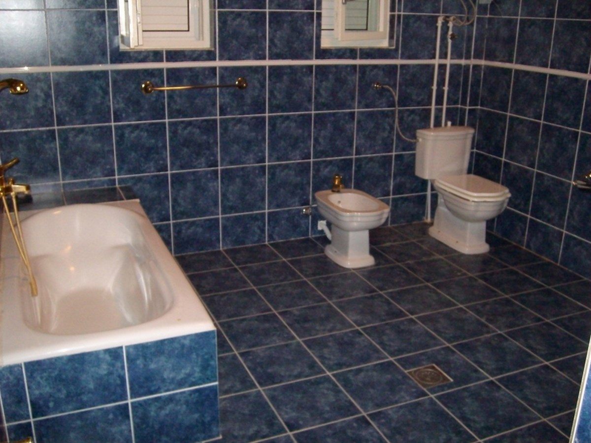 Ein gefliestes Badezimmer mit Badewanne, Bidet und Toilette.