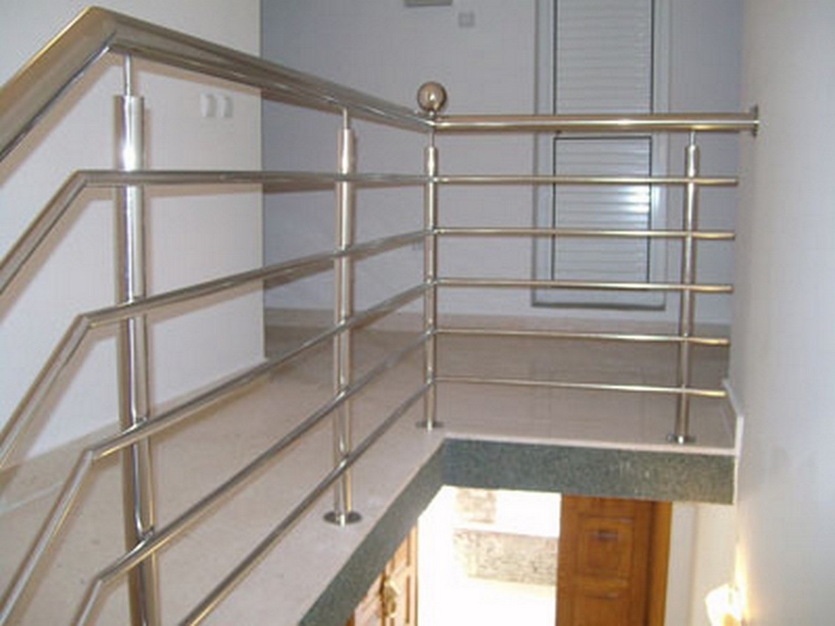 Treppe mit Metallgeländer und weißen Wänden im Flur.