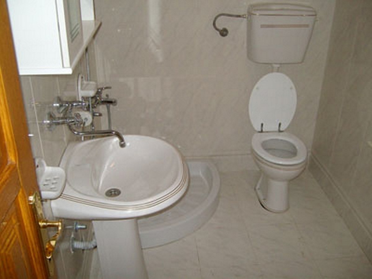 Ein kompaktes Badezimmer mit weißem Waschbecken, Toilette und Duschwanne.