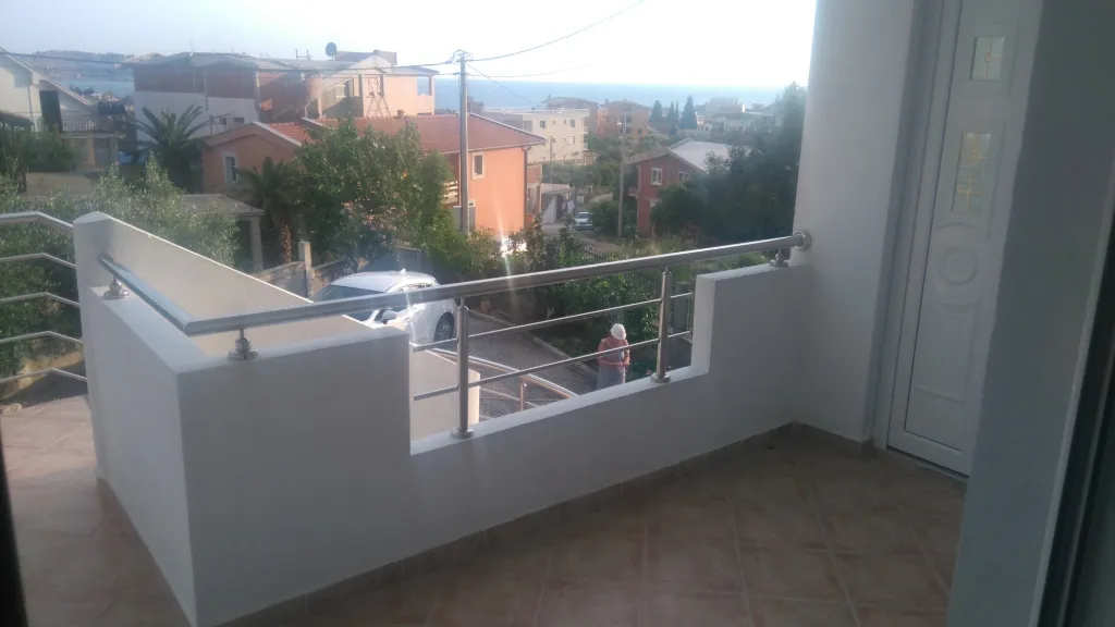 Balkon mit weißen Geländern und Blick auf Stadt und Meer