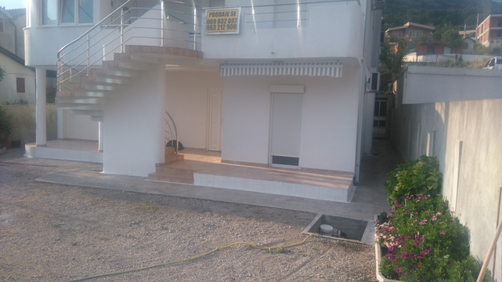 Zweistöckiges Haus zum Verkauf in Šušanj, Montenegro: Fassade mit Außentreppe, Terrasse und gepflegtem Grundstück.
