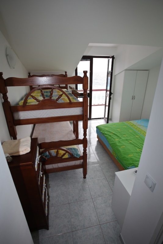 Schlafzimmer mit Etagenbett und Meerblick im Haus, Dobri Vody, Montenegro. Helle Ausstattung, Fliesenboden.