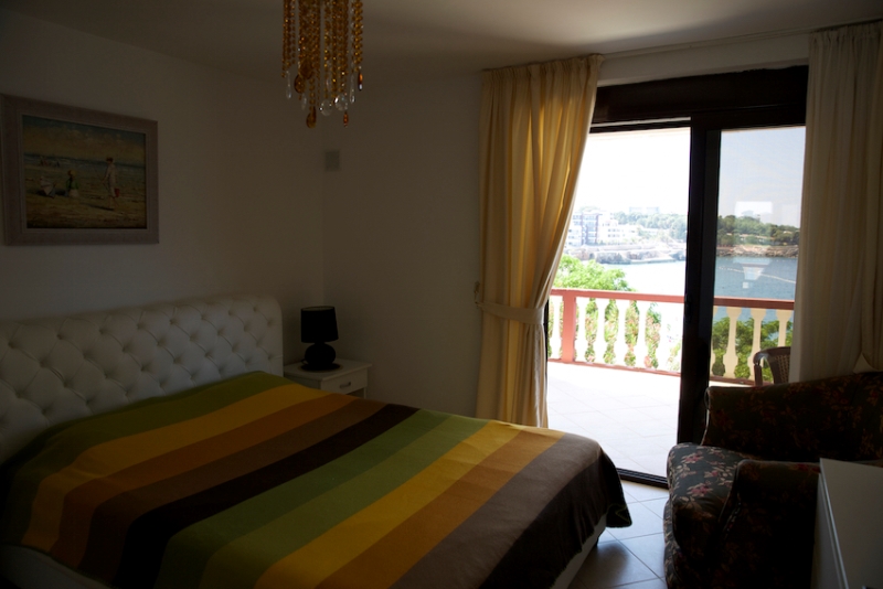 Schlafzimmer in einem Haus in Dobri Vody, Montenegro: Doppelbett, Zugang zur Terrasse mit Panoramablick auf das Meer.