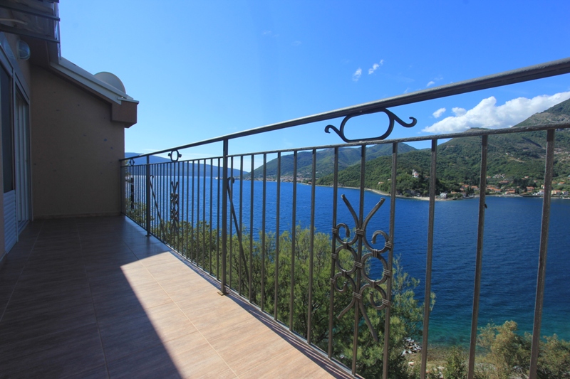 Balkon der Villa in Lepetani, Montenegro, mit schmiedeeisernem Geländer und Panoramablick auf das Meer und die Berge der Bucht von Kotor.