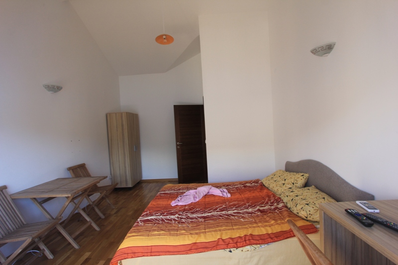 Schlafzimmer in einer Villa in Lepetani, Montenegro: Doppelbett, Holztisch mit Stühlen und Kleiderschrank, Parkettboden.