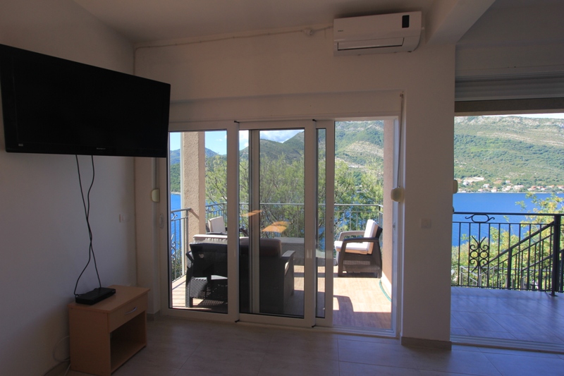 Wohnzimmer mit Zugang zur Terrasse und Panoramablick auf das Meer in der Villa Lepetani, Montenegro.